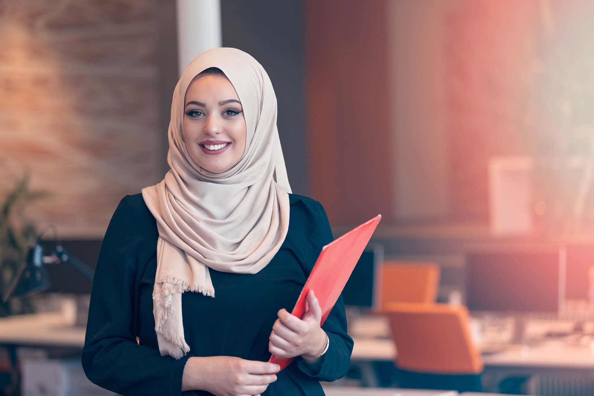 Arabian business woman holding a folder in modern startup office
